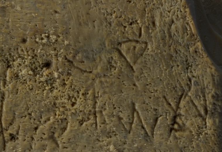 Close-up of Canaanite letters on right side of comb. Close-up of Canaanite letters on right side of comb.